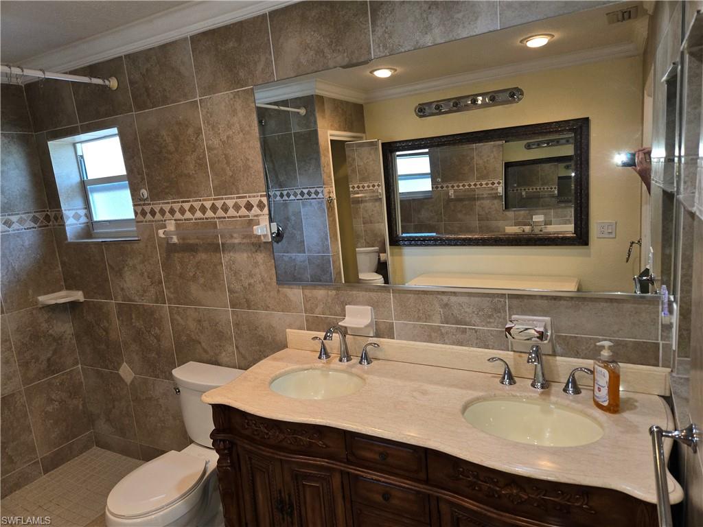 639 Pompano Drive Naples, FL 34110 - Photo 12 of 39 a bathroom with a sink vanity mirror and toilet