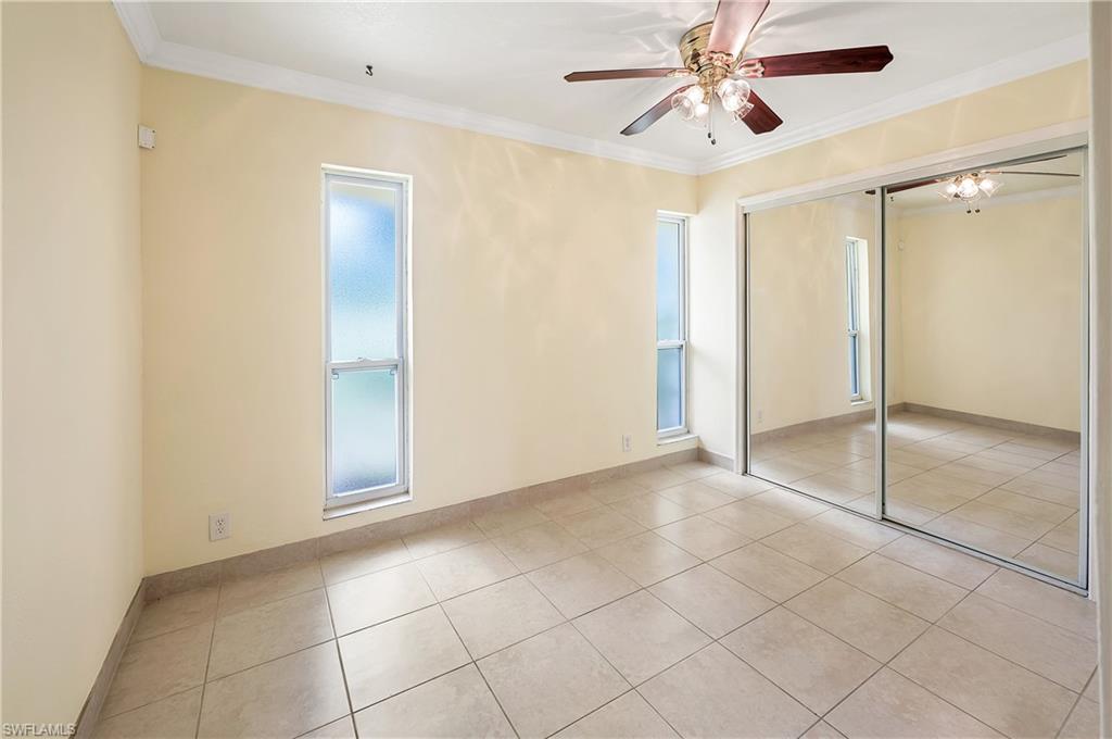 639 Pompano Drive Naples, FL 34110 - Photo 23 of 39 a view of an empty room with window and chandelier fan
