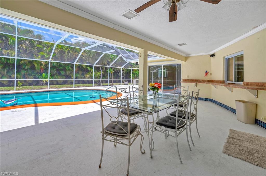 639 Pompano Drive Naples, FL 34110 - Photo 6 of 39 a dining room with furniture and a floor to ceiling window