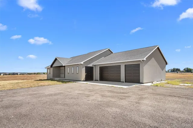 a view of a house with a yard and large tree