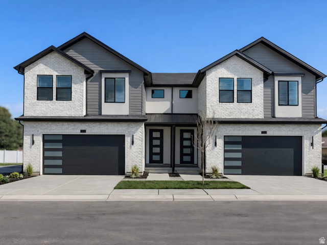 View of front of home with an attached garage, brick siding, and driveway
