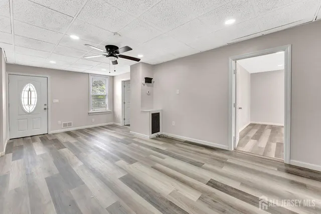 a view of an empty room and window and wooden floor