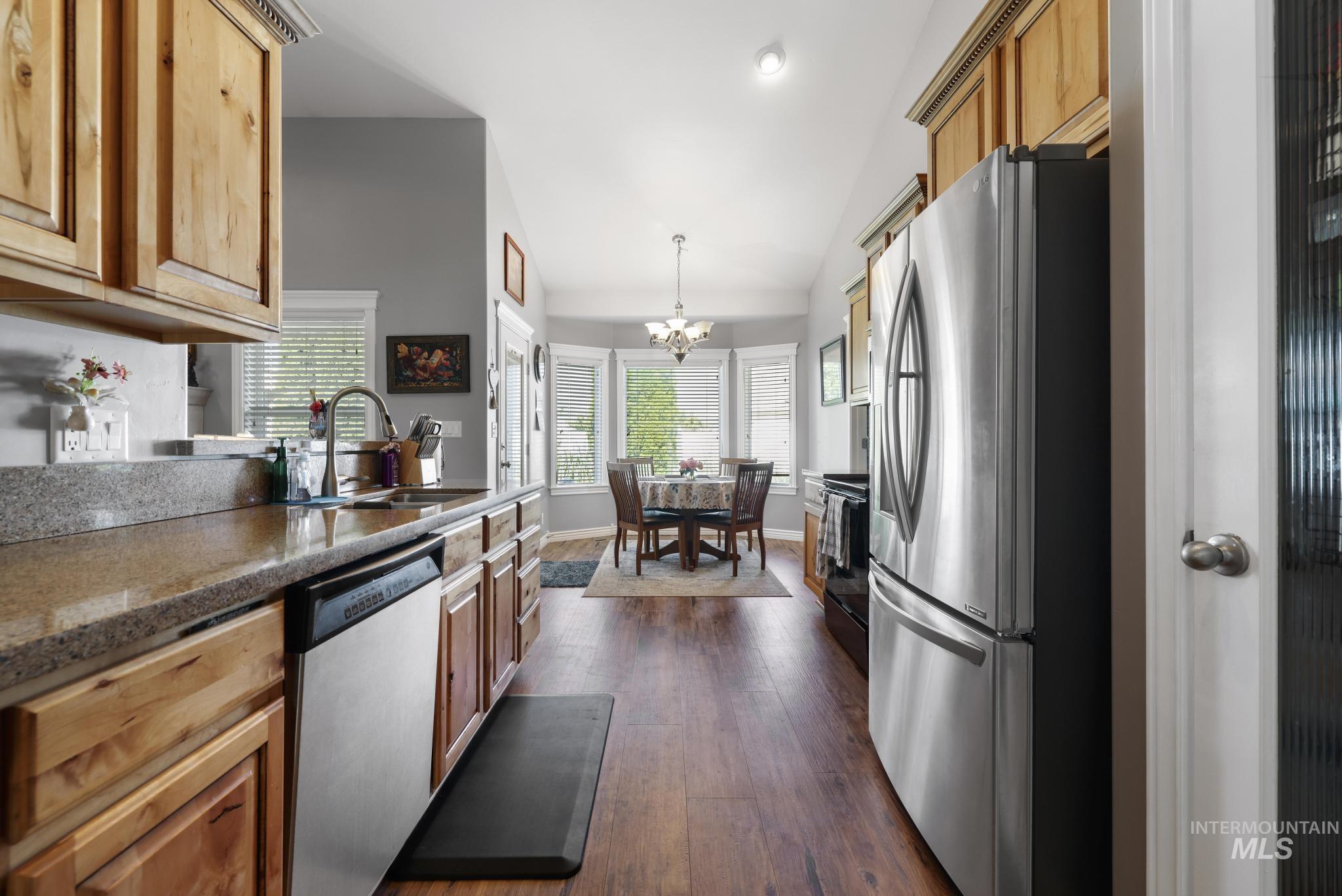 467 Wildrose Loop Twin Falls, ID 83301 - Photo 17 of 46 Kitchen featuring wood-finish flooring, light wood cabinetry, stainless steel appliances, and a granite-style countertop
