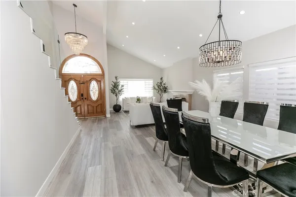 a kitchen with stainless steel appliances kitchen island granite countertop a sink a stove a refrigerator and a oven with wooden floor