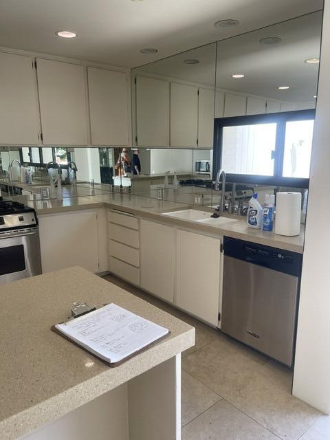 2700 Lawrence Crossley Road, Unit 18 Palm Springs, CA 92264 - Photo 3 of 7 a kitchen with stainless steel appliances granite countertop a sink counter space cabinets and a a refrigerator