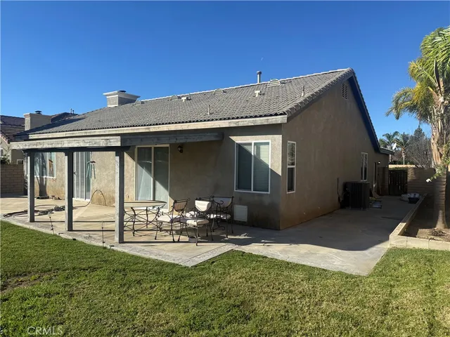 a front view of a house with a garden and chairs