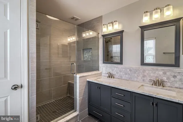 a bathroom with double vanity sinks and a mirror