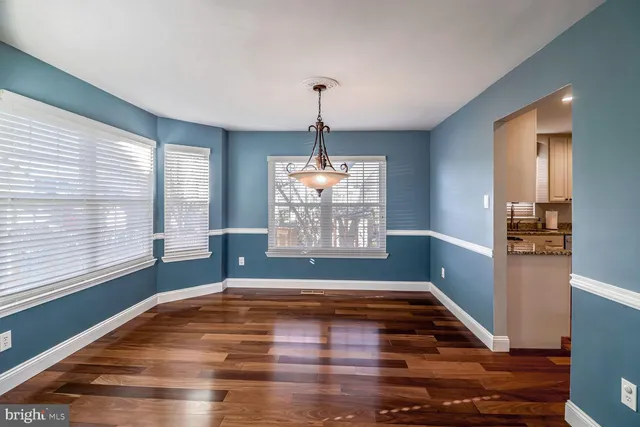 a view of empty room with window and wooden floor