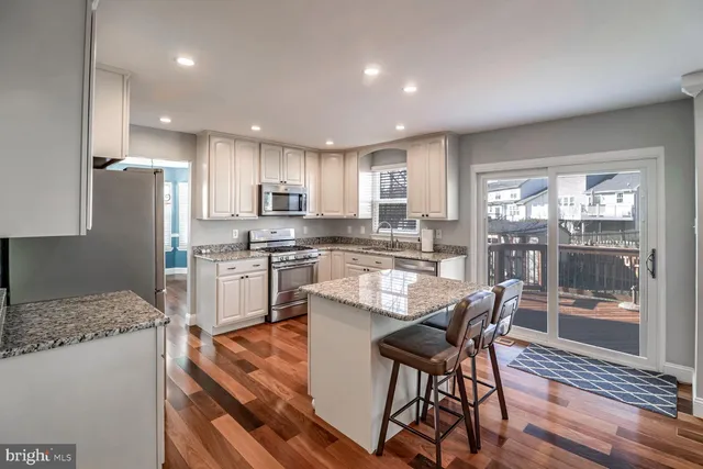 a kitchen with a table chairs refrigerator and microwave