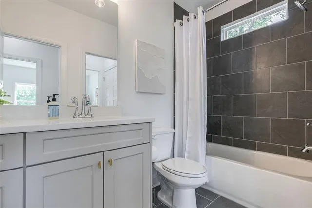 a spacious bedroom with a bed a couch and a chandelier