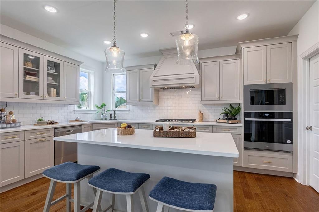 1025 Stonewood Field Road Watkinsville, GA 30677 - Photo 52 of 98 a kitchen with stainless steel appliances granite countertop a sink a stove a refrigerator cabinets and chairs