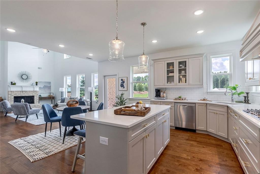 1025 Stonewood Field Road Watkinsville, GA 30677 - Photo 58 of 98 a kitchen with stainless steel appliances granite countertop a stove top oven a sink a dining table and chairs