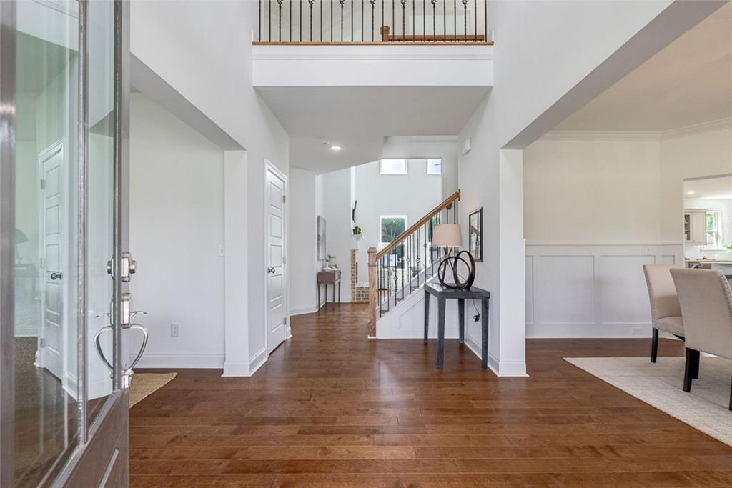 1025 Stonewood Field Road Watkinsville, GA 30677 - Photo 63 of 98 a hallway with wooden floor table and chairs