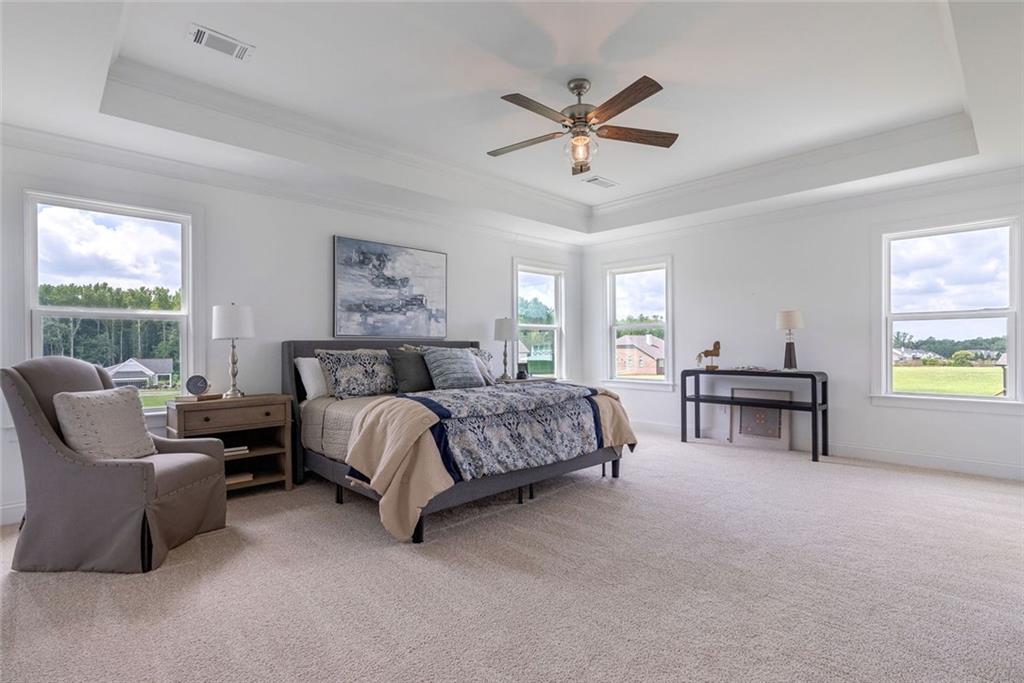 1025 Stonewood Field Road Watkinsville, GA 30677 - Photo 65 of 98 a spacious bedroom with a bed and a chandelier