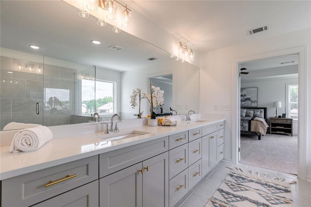 1025 Stonewood Field Road Watkinsville, GA 30677 - Photo 72 of 98 a spacious bathroom with a double vanity sink and a mirror