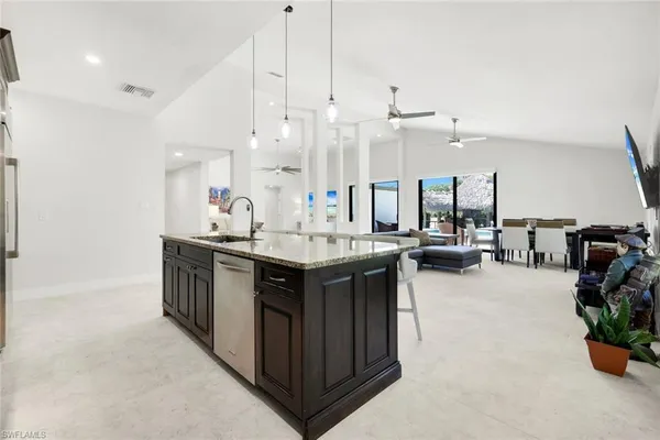 a kitchen with a sink a counter and chairs