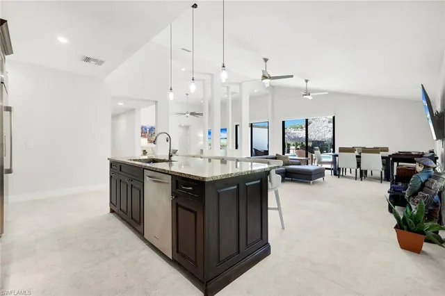 a kitchen with a sink a counter and chairs