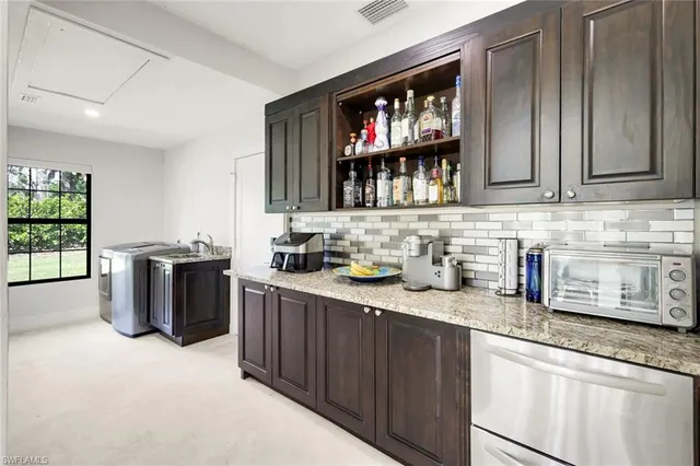 a kitchen with stainless steel appliances granite countertop a sink stove and cabinets