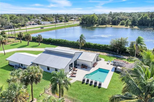 an aerial view of a house with swimming pool garden and lake view
