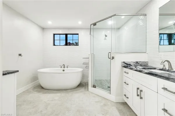 a bathroom with a tub sink and mirror