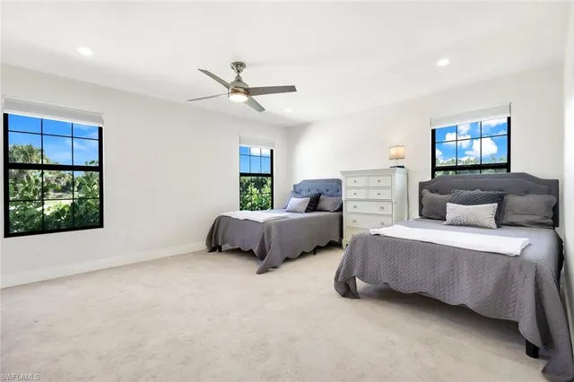 a spacious bedroom with two beds and a window