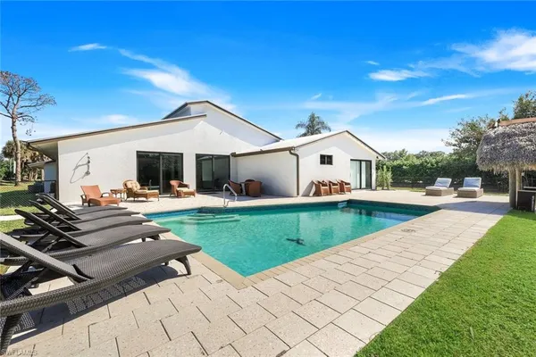 a view of house with swimming pool outdoor seating