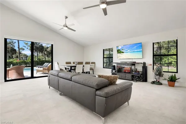 a living room with furniture large window and flat screen tv