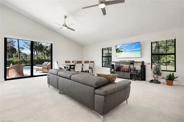 a living room with furniture large window and flat screen tv