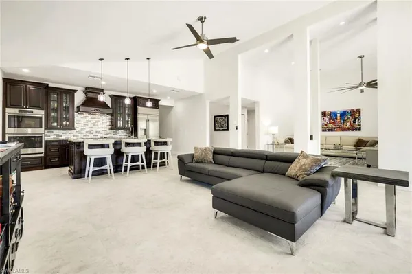 a living room with furniture kitchen view and a large window