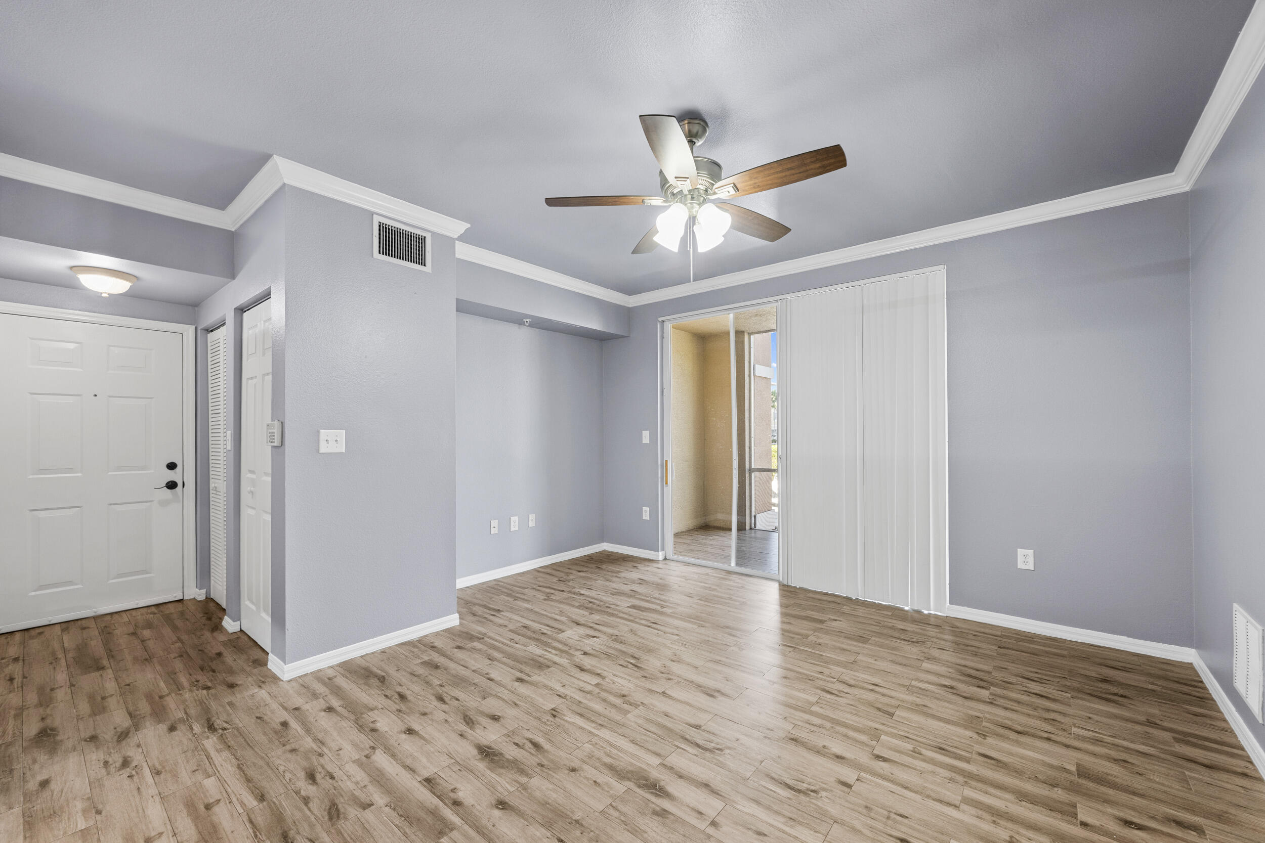 6410 Emerald Dunes Drive, Unit 101 West Palm Beach, FL 33411 - Photo 12 of 39 a view of empty room with wooden floor and ceiling fan