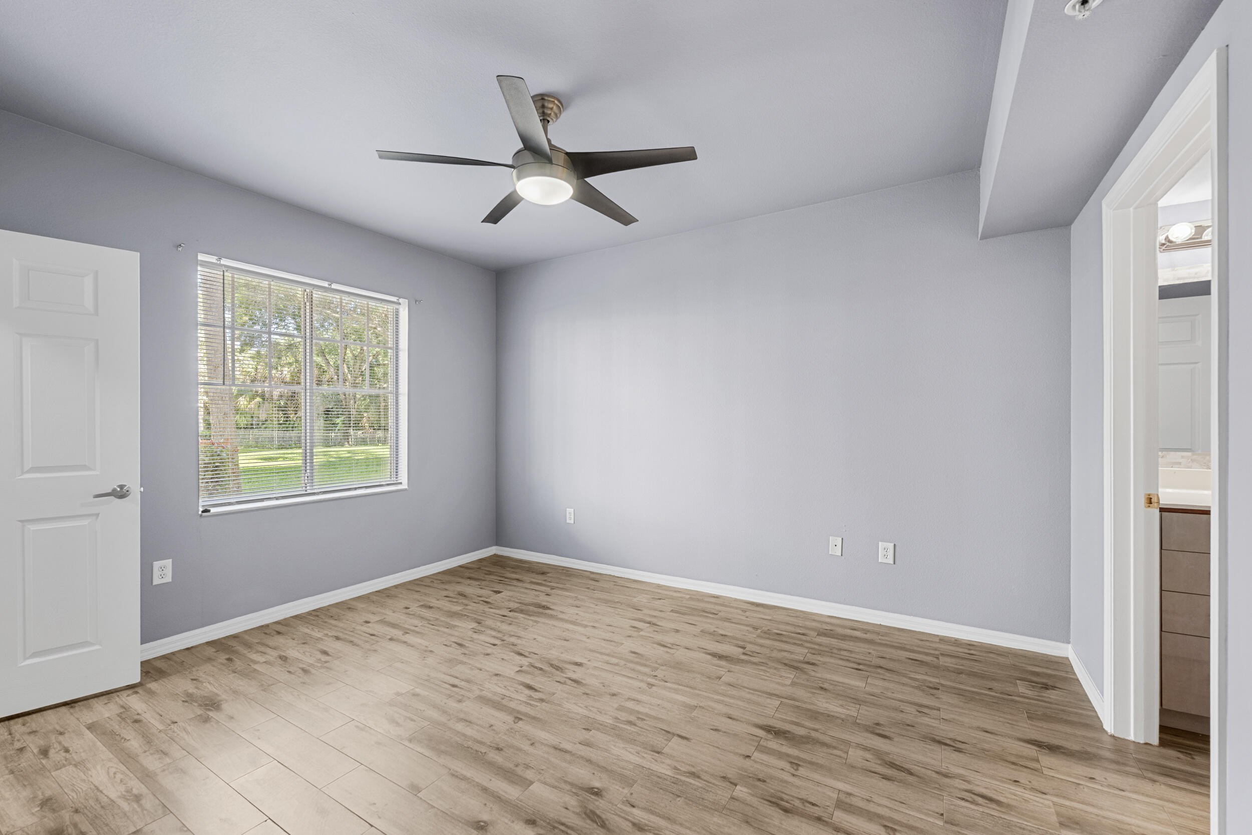 6410 Emerald Dunes Drive, Unit 101 West Palm Beach, FL 33411 - Photo 16 of 39 a view of empty room with wooden floor and fan