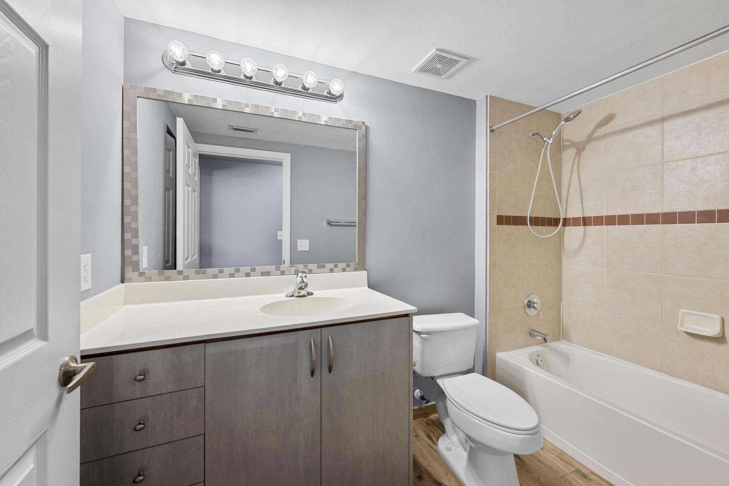 6410 Emerald Dunes Drive, Unit 101 West Palm Beach, FL 33411 - Photo 22 of 39 a bathroom with a sink toilet vanity and shower