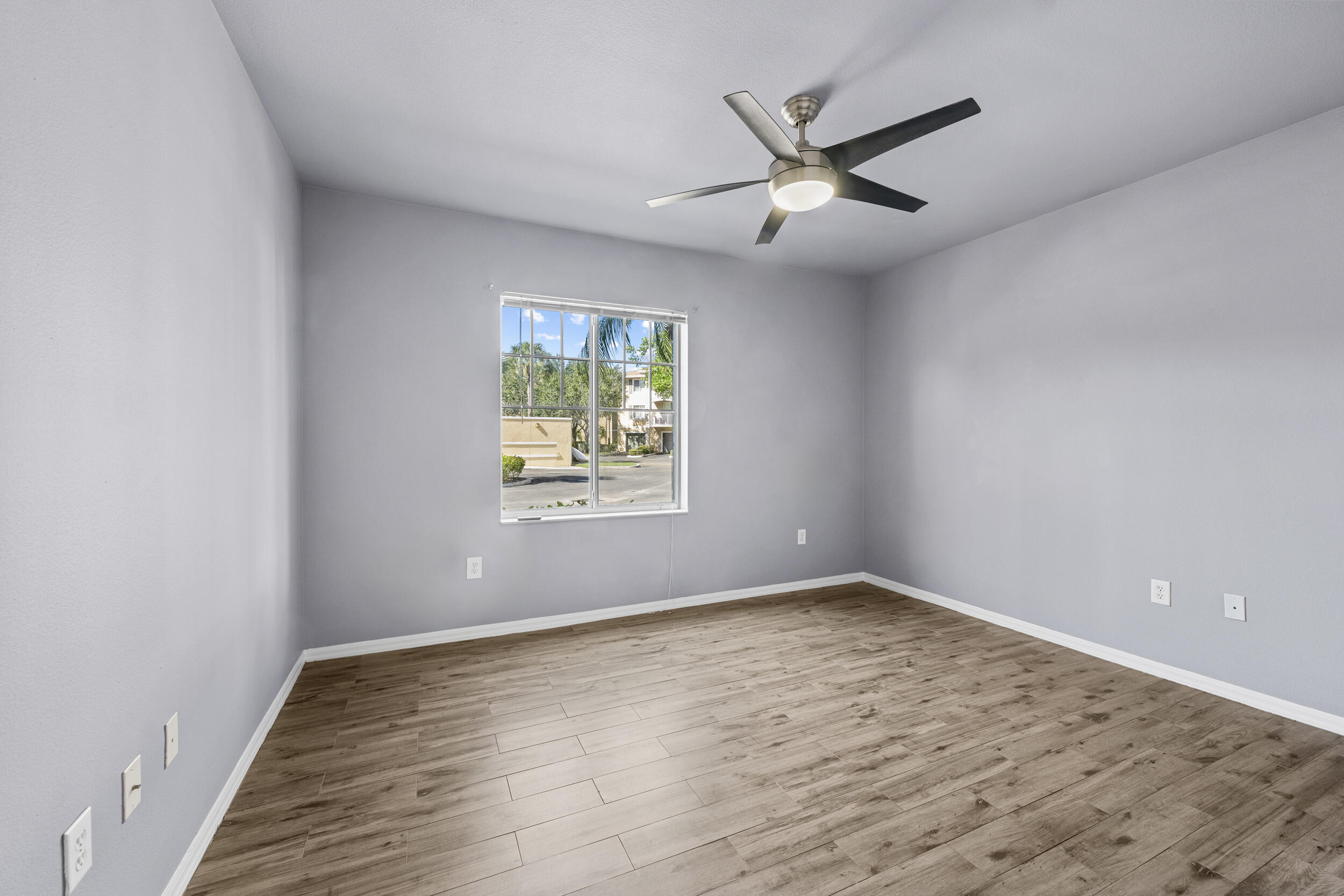 6410 Emerald Dunes Drive, Unit 101 West Palm Beach, FL 33411 - Photo 24 of 39 an empty room with window and ceiling fan