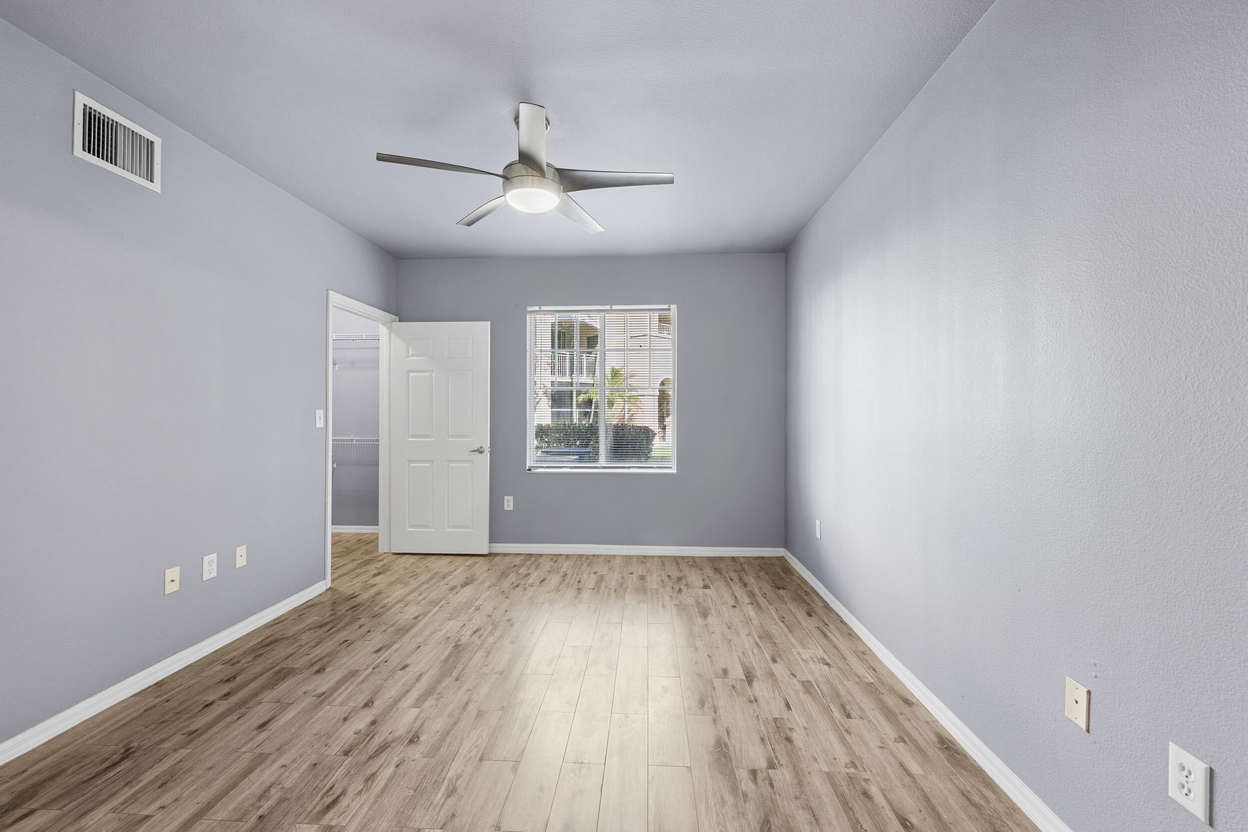 6410 Emerald Dunes Drive, Unit 101 West Palm Beach, FL 33411 - Photo 25 of 39 a view of an empty room with wooden floor and a window