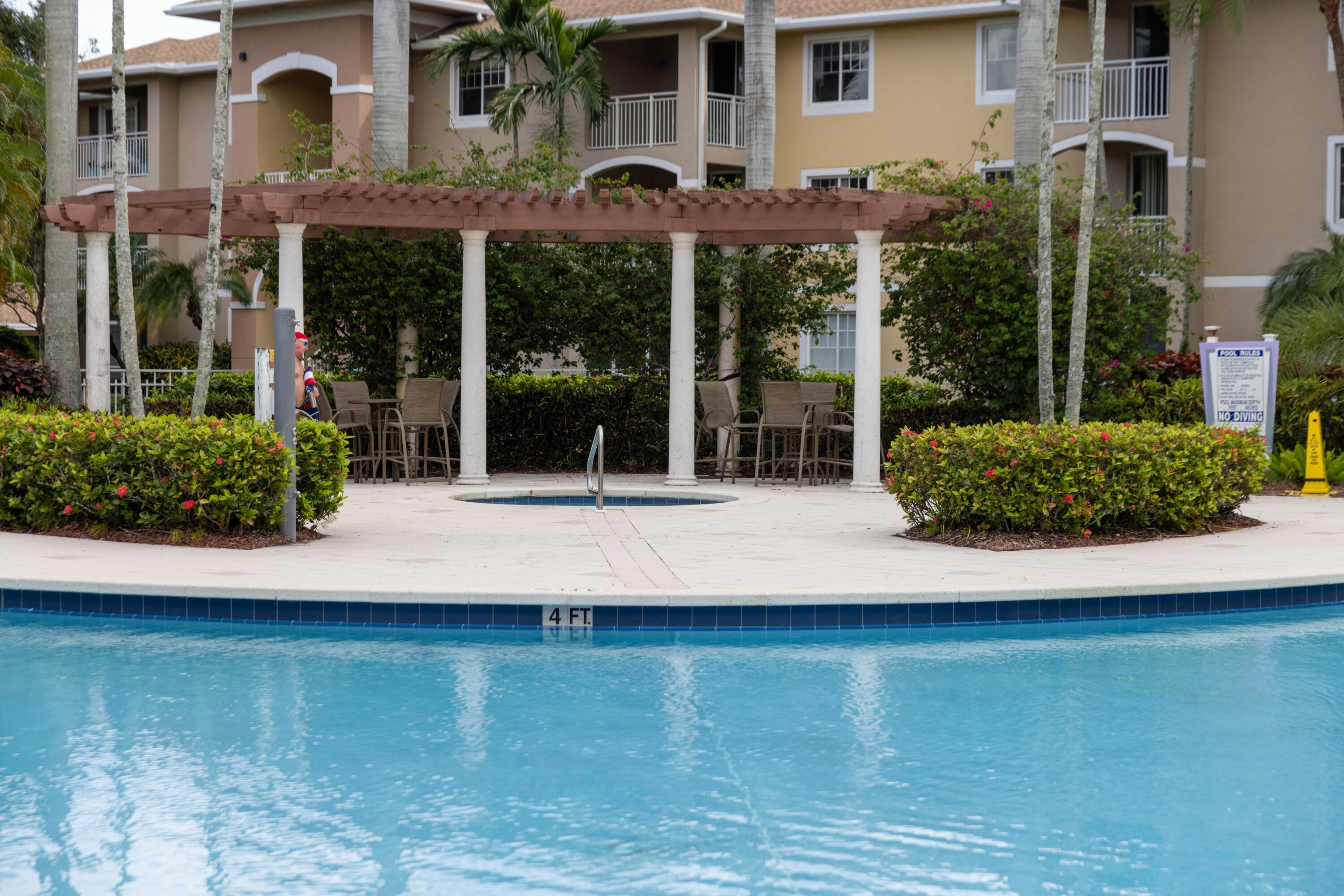6410 Emerald Dunes Drive, Unit 101 West Palm Beach, FL 33411 - Photo 32 of 39 front view of a building with a yard