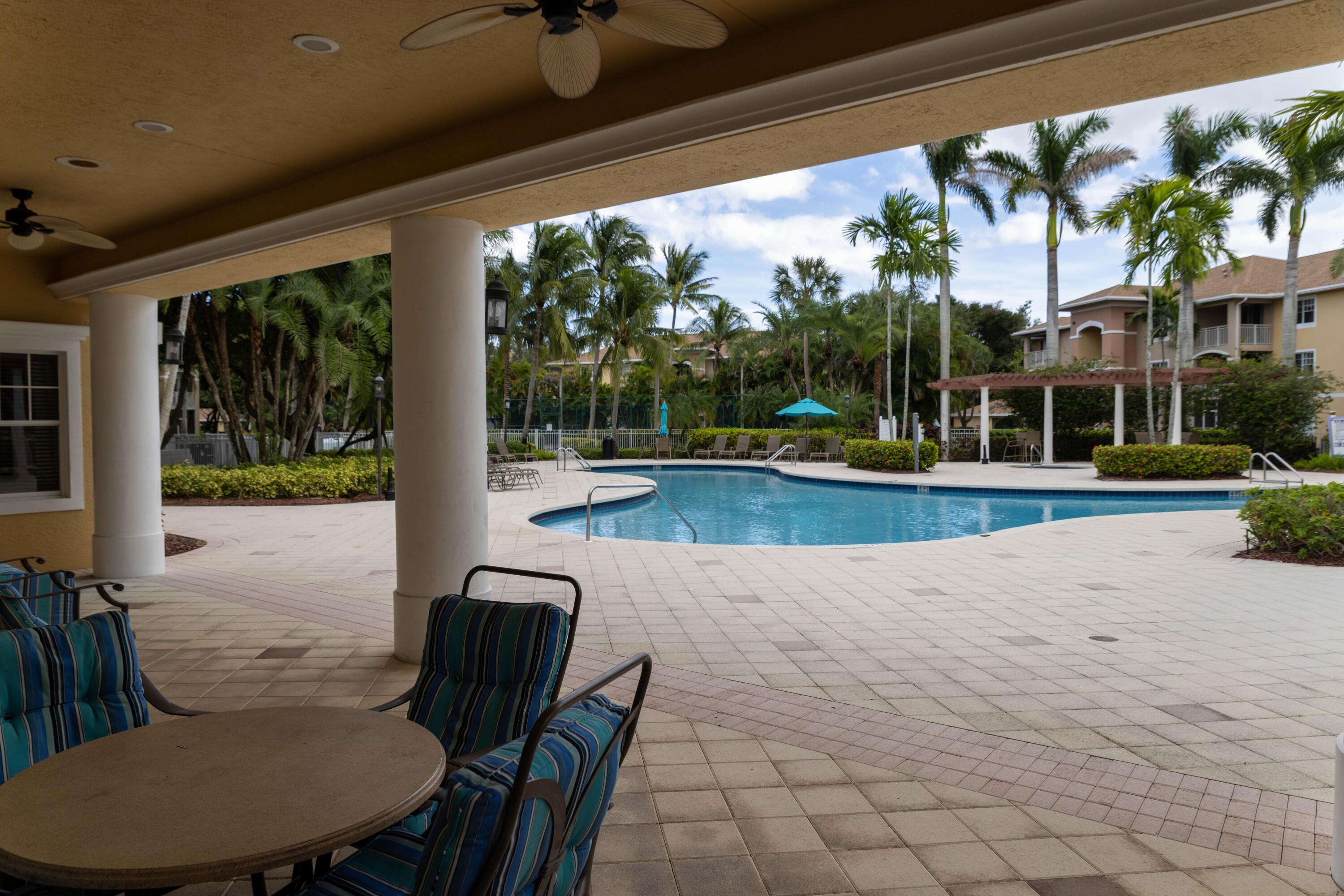6410 Emerald Dunes Drive, Unit 101 West Palm Beach, FL 33411 - Photo 34 of 39 a view of a patio with swimming pool table and chairs