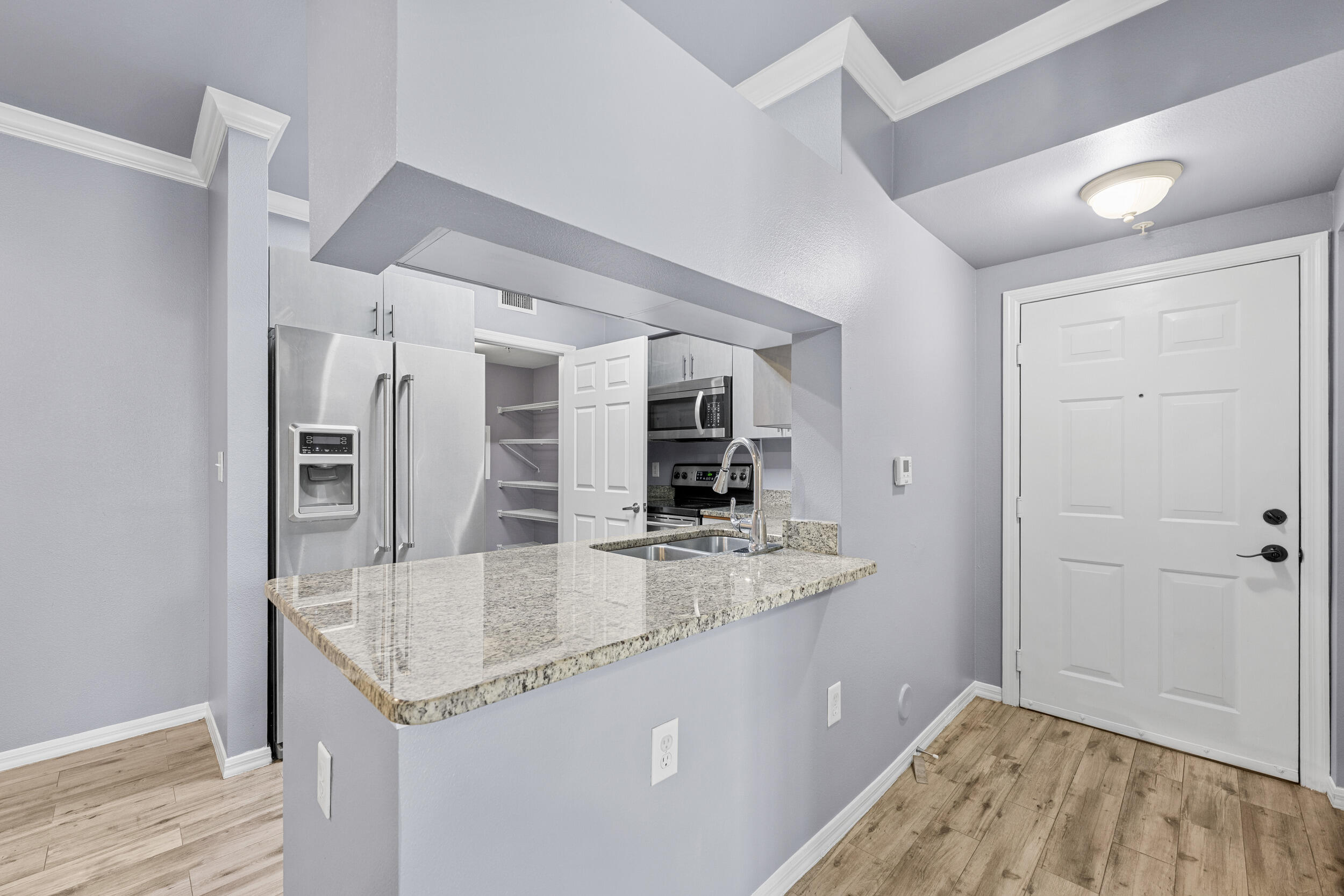 6410 Emerald Dunes Drive, Unit 101 West Palm Beach, FL 33411 - Photo 4 of 39 a kitchen with stainless steel appliances granite countertop a sink and refrigerator