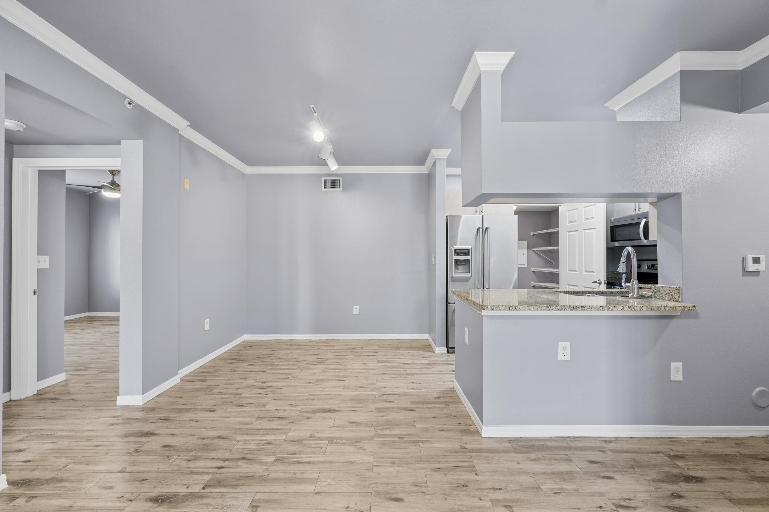6410 Emerald Dunes Drive, Unit 101 West Palm Beach, FL 33411 - Photo 5 of 39 a view of a kitchen with stainless steel appliances wooden floor and chair