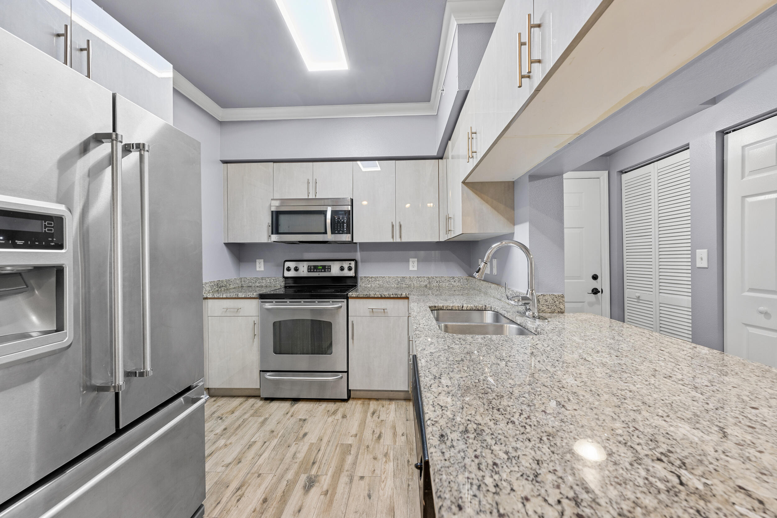 6410 Emerald Dunes Drive, Unit 101 West Palm Beach, FL 33411 - Photo 7 of 39 a kitchen with granite countertop a refrigerator stove and sink