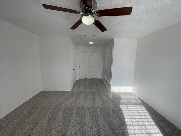 an empty room with fan and windows