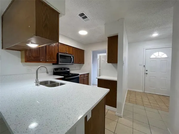 a kitchen with a sink a counter top space cabinets and stainless steel appliances