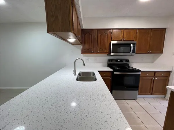 a kitchen with a sink a stove a microwave and cabinets