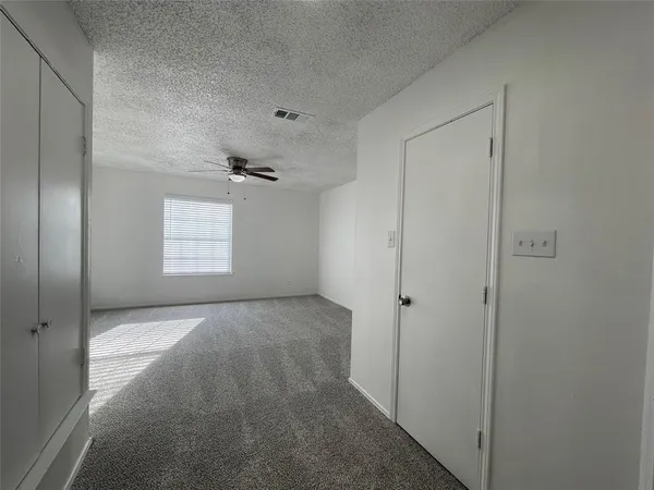 an empty room with windows and closet