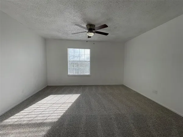 an empty room with windows and ceiling fan view