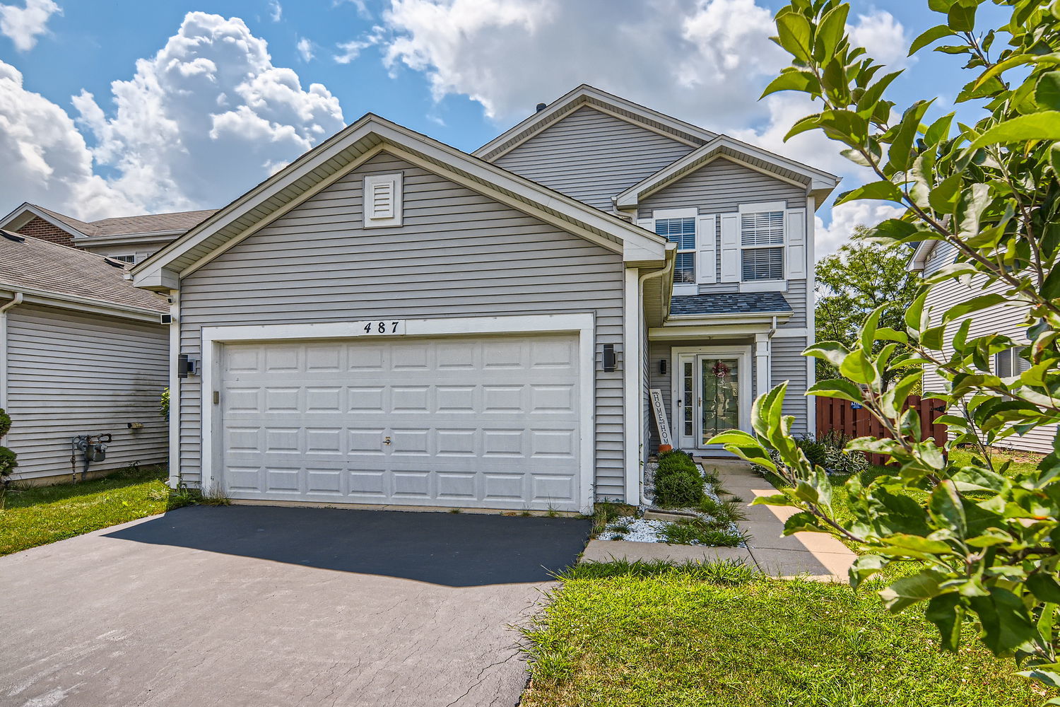 487 West Hamlin Lane Round Lake, IL 60073 - Photo 2 of 28 a front view of a house with a yard and garage