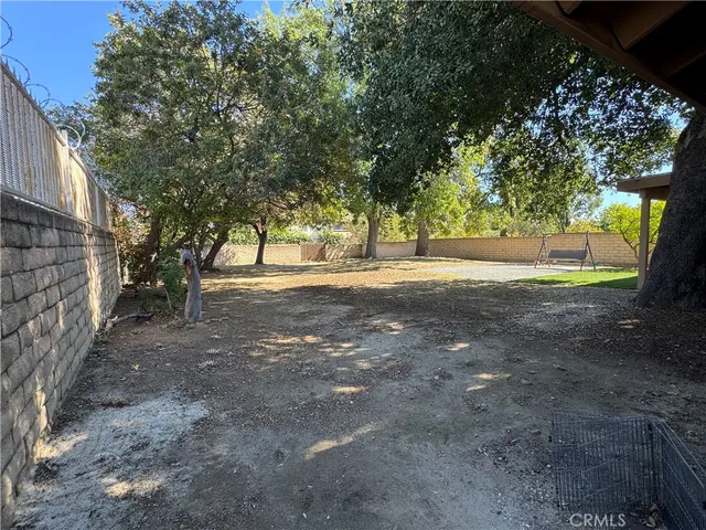 a view of dirt yard with a large tree