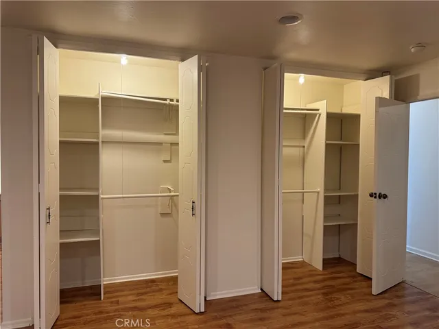 a view of walk in closet with wooden floor