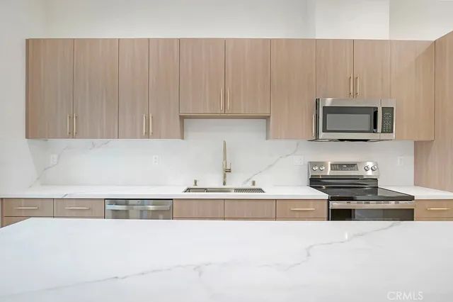 a kitchen with granite countertop white cabinets and stainless steel appliances