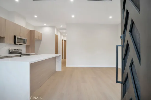 a view of kitchen with stainless steel appliances a refrigerator and a stove top oven