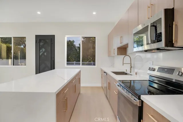 a kitchen that has a sink and a stove in it